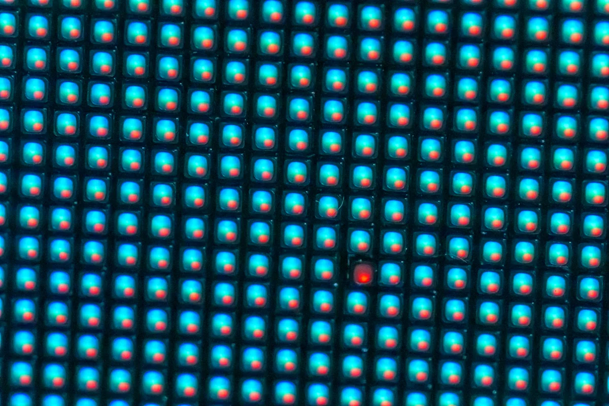 Macro photograph of a defective RGB pixel among illuminated LEDs on a video wall