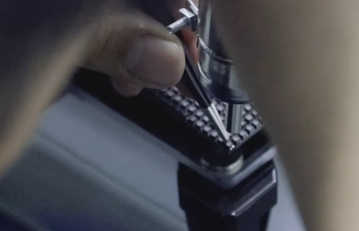 Close-up of a hot-air nozzle and tweezers at an SMD LED during a repair demonstration