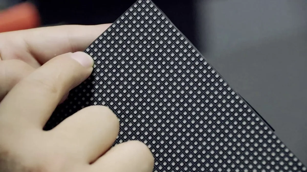 Hands inspecting the LED package array on a real SMD display module